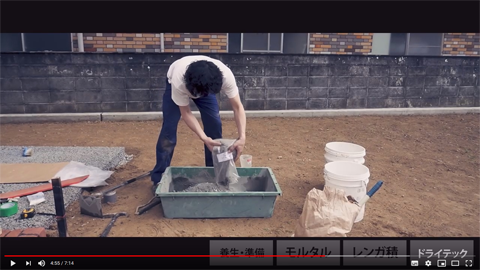 今回は透水性コンクリートを生コン屋に注文せずに自分で作る。透水性コンクリート用の骨材を一袋、そしてF材を一袋、水を1リットル。これをトロ舟で混ぜていく。